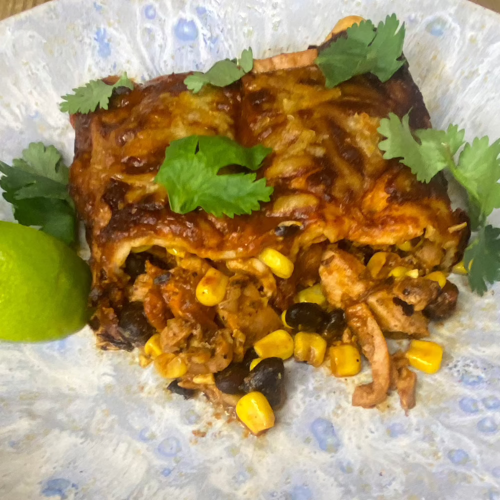 Chicken enchiladas with black beans & corn, fire roasted red pepper & achiote sauce