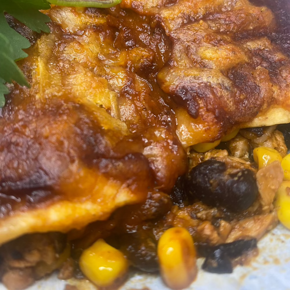 Chicken enchiladas with black beans & corn, fire roasted red pepper & achiote sauce