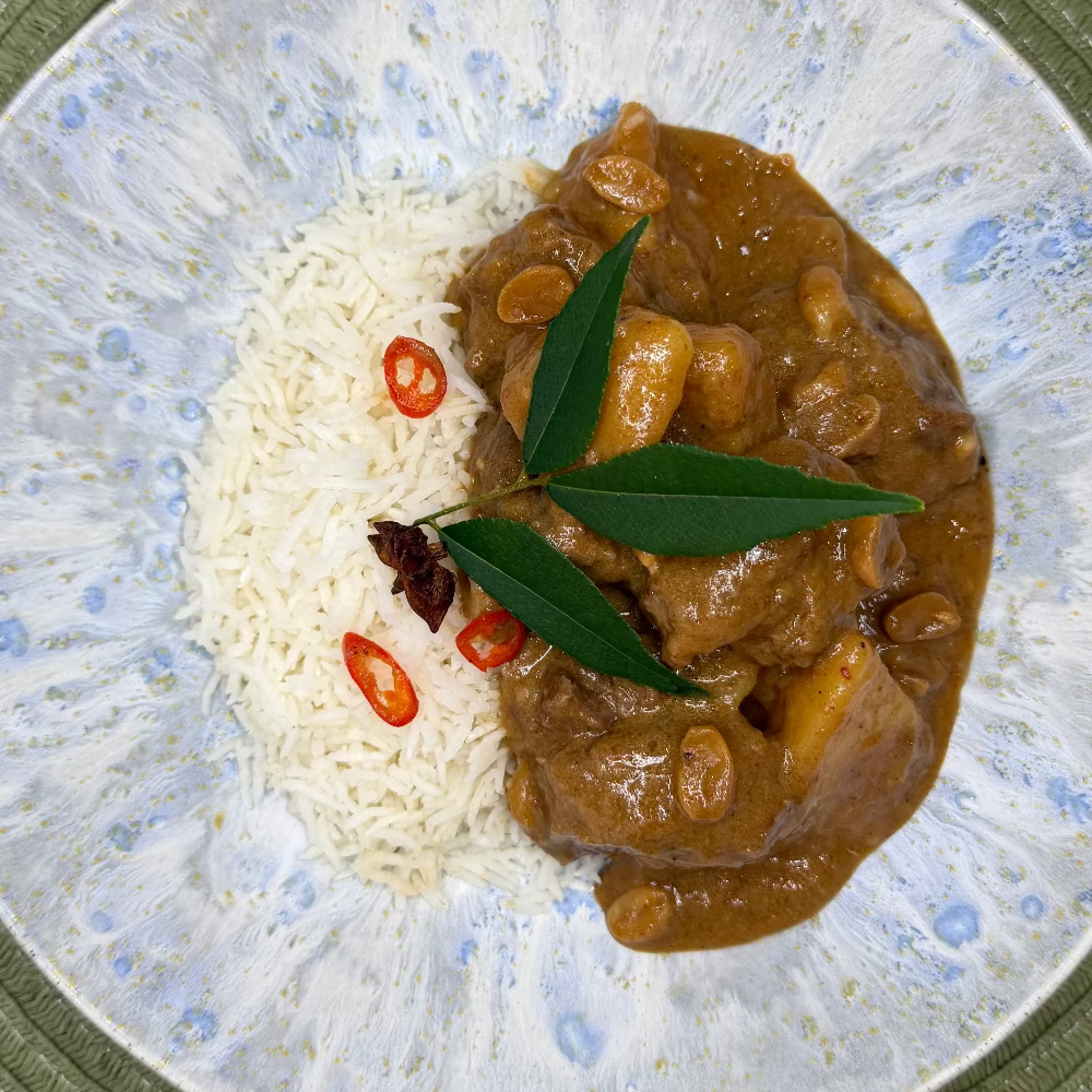 Slow-cooked beef cheek Massaman curry with tender potatoes in a rich, aromatic coconut curry sauce with Jasmine rice