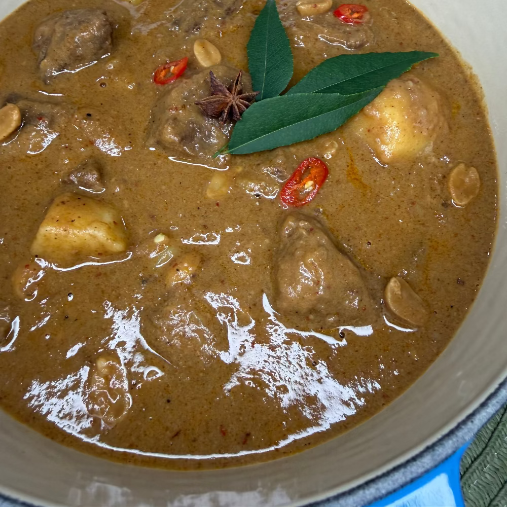 Slow-cooked beef cheek Massaman curry with tender potatoes in a rich, aromatic coconut curry sauce.